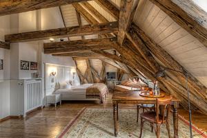 an attic room with a bed and a table at Hotel Orphée - Großes Haus in Regensburg