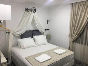 a bedroom with a bed with two white towels on it at Nova Citrus Otel in Siğacık