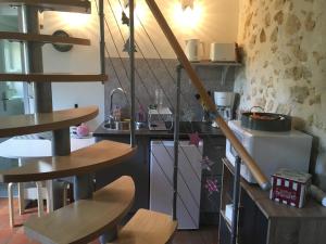a kitchen with a spiral staircase in a kitchen at La Marchanderie in Spay