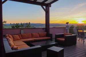 a living room with a couch and chairs on a balcony at Hotel Cvilín in Krnov