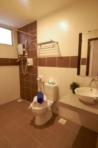 y baño con aseo y lavamanos. en 3 Bedrooms at Lagoon Park Resort en Melaka