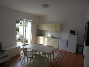 a kitchen with a table and chairs in a room at Neva Apartments in Šimuni +16 photos
