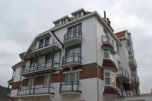 een wit gebouw met balkons aan de zijkant bij Hotel Astel in De Haan
