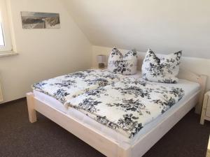 a bedroom with a bed with blue and white sheets and pillows at Haus Selma in Zingst