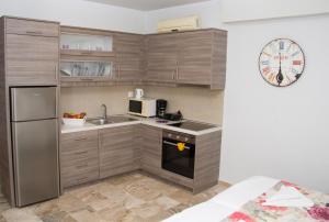 a small kitchen with a sink and a refrigerator at Attalos Apartments in Agia Pelagia