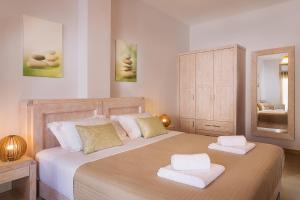 a bedroom with a large bed with two towels on it at Mirto's Studios in Fira