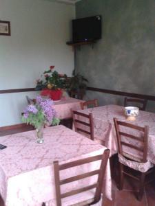 a dining room with two tables and a vase of flowers at Regina di cuori in LʼAquila
