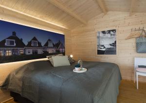a bedroom with a bed in a wooden room at Lodgehotel de Lelie in Makkum