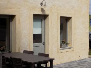 een tafel en stoelen voor een gebouw met een deur bij Modern Holiday Home in Florenville with Garden in Chassepierre