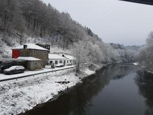 VerlaineにあるCharming Holiday Home In Durbuy with Gardenの雪の川の横の建物