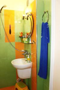 Un baño colorido con lavabo y ducha. en Guesthouse Planinsko Gnezdo, en Tŭzha