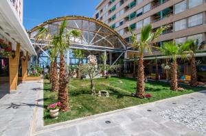 a courtyard with palm trees in a building at Phoenicia Royal Hotel in Mamaia Nord