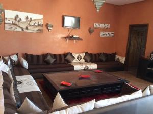 ein Wohnzimmer mit einem Sofa und einem Tisch in der Unterkunft Villa TYCOZ in Marrakesch