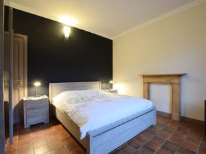 sypialnia z białym łóżkiem i czarną ścianą w obiekcie Quaint Holiday Home in Gouvy with Sauna w mieście Rogery