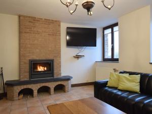 sala de estar con chimenea y TV en Holiday Home in Gouvy Ardennes with Sauna, en Rogery