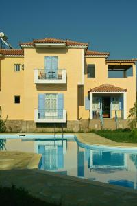 a building with a swimming pool in front of a house at Villa Marita in Lisvórion