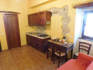 a kitchen with a table and a stove top oven at La Torre dell'Orologio 2.0 in Roccasicura