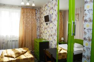 Habitación con 1 dormitorio con 1 cama y TV. en Orange Club, en Zarechnyy