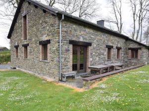 NadrinにあるSpacious Holiday Home in Houffalize with Barbecueの石造りの建物(ピクニックテーブル、ベンチ付)