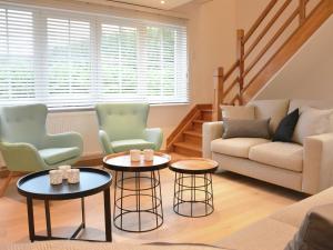 ein Wohnzimmer mit 2 Stühlen und 2 Tischen in der Unterkunft Superb holiday home with garden in Serinchamps in Serinchamps