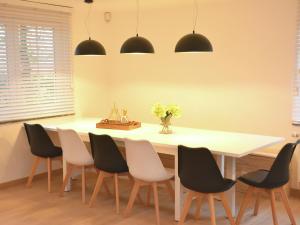 a dining room with a white table and chairs at Superb holiday home with garden in Serinchamps in Serinchamps