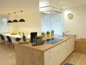 eine Küche mit einer Theke mit einer Spüle und einem Tisch in der Unterkunft Superb holiday home with garden in Serinchamps in Serinchamps