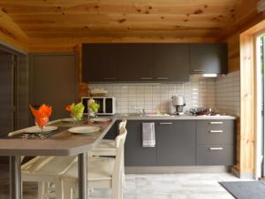 una cucina con tavolo e sedie in una stanza di Magnificent Chalet in Ferri res Ardenne with Private Terrace a Vieuxville