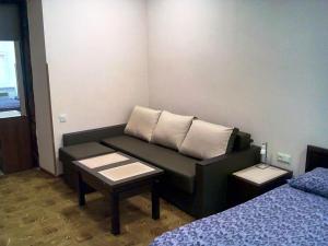 リヴィウにあるSkovoroda apartmentのソファ、ベッド1台、テーブルが備わる客室です。