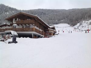 eine Skihütte im Schnee mit Leuten auf den Pisten in der Unterkunft Am Trogwohl in Sölden