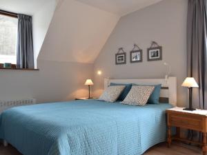 ein Schlafzimmer mit einem blauen Bett mit zwei Lampen in der Unterkunft Holiday Home in Ardennes with garden seating and barbecue in La-Roche-en-Ardenne