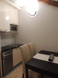 Una pequeña cocina con una mesa, una estufa y un microondas. en Apartments Villa Aurora, en Ražanac