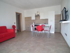 a living room with a red couch and a table and chairs at fausthome in Assemini