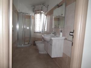 a bathroom with a sink and a shower and a toilet at fausthome in Assemini +18 photos