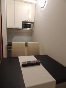 Una pequeña cocina con una mesa y un microondas. en Apartments Villa Aurora, en Ražanac