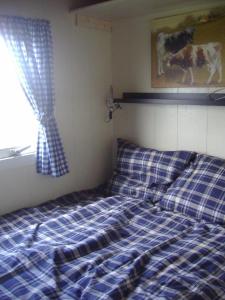 Your Cozy Waggon at the Cows' Paradise في أمستردام: سرير في غرفة نوم مع بطانية مصدية