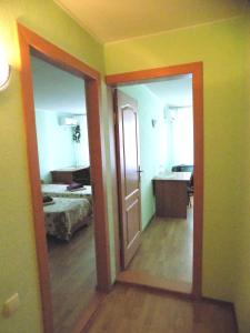 ein Zimmer mit einer Tür und ein Schlafzimmer mit einem Bett in der Unterkunft Elektromash Hotel in Tiraspol