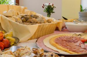 uma mesa com um cesto de diferentes tipos de alimentos em Hotel Tynec em Týnec nad Sázavou
