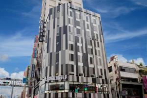 a tall building on the corner of a city street at Single Inn-Kaohsiung Station in Kaohsiung