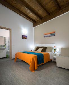 a bedroom with a bed with an orange blanket at Arricàmpati Airport Home & Bringo Car Rental in Carini