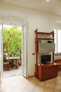 uma sala de estar com uma televisão e uma porta de vidro deslizante em La Casa del Gallerista em Manarola