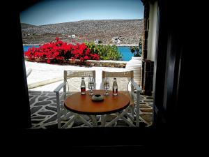 a table and two chairs with drinks on a patio at Vardia Bay Studios in Karavostasi
