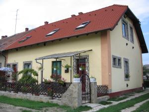 una pequeña casa amarilla con techo rojo en Pleiveisz Apartman, en Sárvár