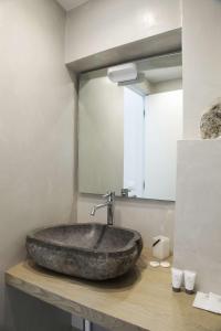 uma casa de banho com um lavatório de pedra e um espelho. em La Casa del Gallerista em Manarola