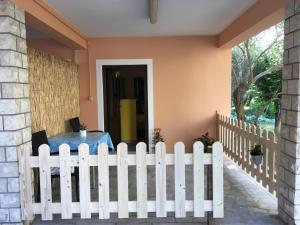 a white picket fence in front of a house at Apartments Tartuga in Rab