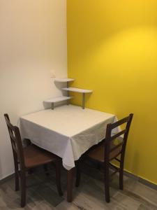 un tavolo con due sedie e una parete gialla di Apartments Tartuga a Rab