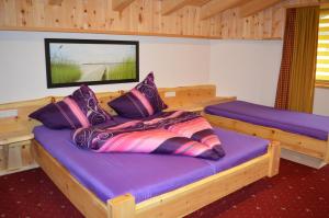 a bedroom with a bed with purple sheets and pillows at Am Trogwohl in Sölden