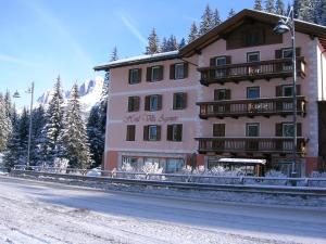 a large pink building on the side of a road at Hotel Villa Agomer in Canazei