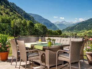 a table and chairs on a patio with a view of mountains at Aktivhotel Gasteiner Einkehr in Dorfgastein