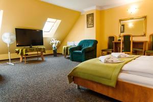 ein Hotelzimmer mit einem Bett und einem Flachbild-TV in der Unterkunft Motel Arkadia in Koszalin