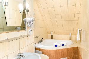 een badkamer met een wastafel en een ligbad bij Motel Arkadia in Koszalin